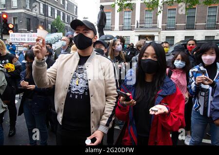 Maskierte Demonstranten versammeln sich mit Kerzen vor der chinesischen Botschaft in London, Großbritannien, zum 32. Jahrestag des Massakers vom 4. Juni auf dem Platz des Himmlischen Friedens in China. Stockfoto