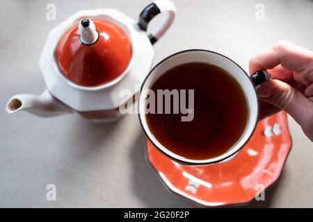 Hand hält eine Teetate. Entspannender Tee. Stockfoto