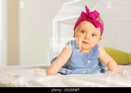 Kleines Baby Mädchen im Kleid mit roter Schleife Stockfoto