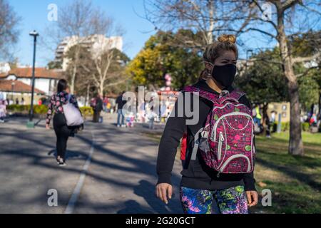 BUENOS AIRES, ARGENTINIEN - 07. Nov 2020: Mädchen, die mit Rucksack und Gesichtsmaske durch den hundertjährigen Park der Autonomen Stadt Buenos Aires mai spazieren Stockfoto