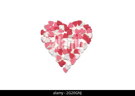 Süße Herzen. Rosa, rote und weiße herzförmige Zuckerstreuseln. Buntes Herz aus vielen kleinen Herzen. Valentinstag oder Muttertag Hintergrund Stockfoto