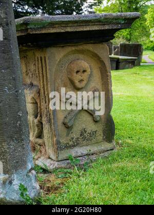 Schädel- und Kreuzknochen-Schnitzerei auf Kopfstein Eyam Village Derbyshire UK Stockfoto