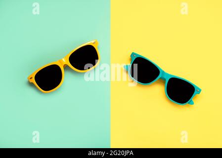 Draufsicht auf grüne und gelbe Sonnenbrille auf grünem und gelbem Hintergrund Stockfoto