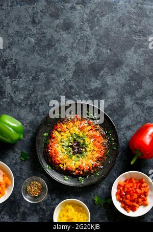 Regenbogen Veggie Paprika Pizza Kruste auf blauem Stein Hintergrund mit freiem Text Raum. Vegetarisch vegan oder gesundes Essen Konzept. Draufsicht, flaches Lay Stockfoto
