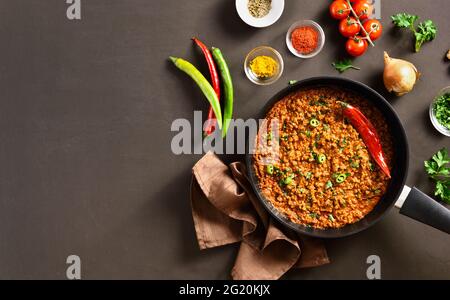 Indische und pakistanische Gerichte. Keema-Kerk in Bratpfanne auf braunem Hintergrund mit Platz zum Kopieren. Draufsicht, flach liegend Stockfoto