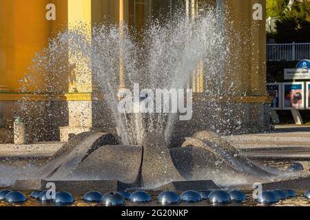 Marianske Lazne, Tschechische Republik - Mai 30 2021: Nahansicht des Wasserbrunnens. Gelbe Kolonnade Gebäude im Hintergrund. Kurstadt. Stockfoto