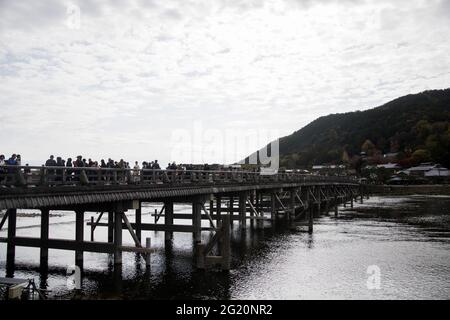 KYOTO, JAPAN - Dec 11, 2019: Kyoto, Japan-26 Nov, 2019: Togetsu-kyo Brücke über Katsuragawa Fluss mit buntem Waldberg Hintergrund in Arashiy Stockfoto