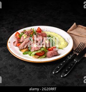 Kartoffel, Rindersteak, romano und Gemüsesalat auf Holzboden, Draufsicht. Ausgewogene Ernährung gesundes Essen auf schwarzem Hintergrund. Vorspeise oder Snack Stockfoto