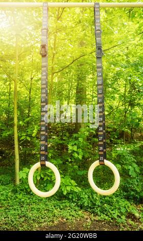 Turnringe mit nummerierten Riemen, die in einem Park hängen. Stockfoto