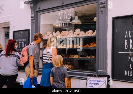 Kunden, die in Cornish Bakery Window in der St. Ives Bakery, Fore Street, St. Ives, Cornwall, Großbritannien, Juni 2021 Stockfoto