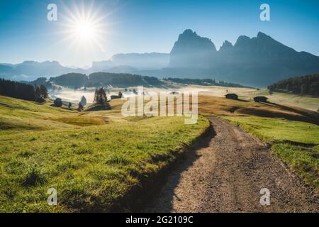 Sonnenaufgang in den italienischen Dolomiten. Straße und Wiesen auf der Seiser Alm oder Seiser Alm, Provinz Bozen, Südtirol, Italien, Europa Stockfoto