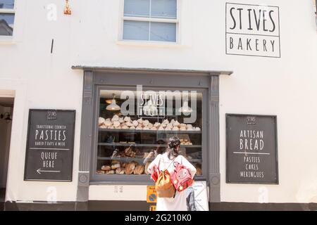 Frau, die im Fenster von St. Ives Bakery, Cornish Bakery, Fore Street, St. Ives, Cornwall, Großbritannien, Juni 2021 Stockfoto