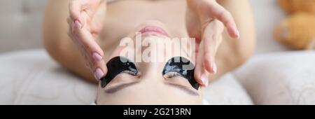 Frau mit Handtuch auf dem Kopf kleben schwarze Flecken unter Augen Stockfoto
