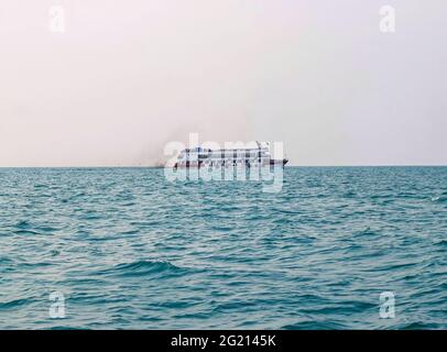 Das Fährschiff der Bucht von Bengalen raucht aus seinem Kamin. Schwarze Abgase, die nach der Zündung des Hauptmotors aus dem Kamin eines festgetäuten Tankers stammen. Stockfoto