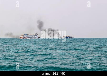 Das Fährschiff der Bucht von Bengalen raucht aus seinem Kamin. Schwarze Abgase, die nach der Zündung des Hauptmotors aus dem Kamin eines festgetäuten Tankers stammen. Stockfoto