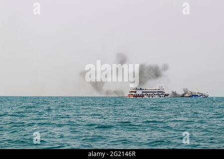 Das Fährschiff der Bucht von Bengalen raucht aus seinem Kamin. Schwarze Abgase, die nach der Zündung des Hauptmotors aus dem Kamin eines festgetäuten Tankers stammen. Stockfoto