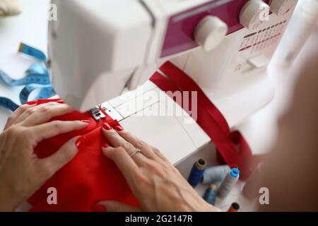 Nahaufnahme der Schneiderin, die an einer elektrischen Nähmaschine arbeitet Stockfoto