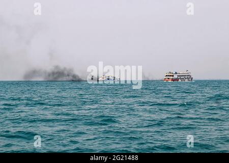 Das Fährschiff der Bucht von Bengalen raucht aus seinem Kamin. Schwarze Abgase, die nach der Zündung des Hauptmotors aus dem Kamin eines festgetäuten Tankers stammen. Stockfoto