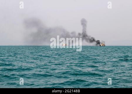 Das Fährschiff der Bucht von Bengalen raucht aus seinem Kamin. Schwarze Abgase, die nach der Zündung des Hauptmotors aus dem Kamin eines festgetäuten Tankers stammen. Stockfoto