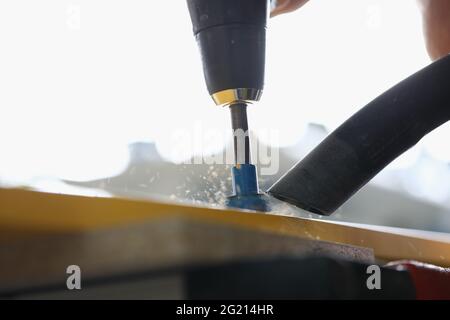 Nahaufnahme des Bohrlochs des Vorarbeiters in der gelben Holzdiele Stockfoto