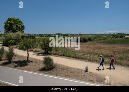 Barcelona, Spanien. Juni 2021. Zwei Spaziergänger sehen sich das Erholungsgebiet am Rande des Baix Llobregat Landwirtschaftsparks und die Start- und Landebahnen des Flughafens El Prat an.das Projekt zur Erweiterung einer der Start- und Landebahnen des Flughafens Josep Tarradellas, der im Volksmund als Barcelona's Prat Airport bekannt ist, Droht, in ein geschütztes Gebiet der Feuchtgebiete des Naturparks Delta del Llobregat einzudringen und eine bittere Debatte über das Gleichgewicht zwischen Wirtschaft und Umweltschutz zu eröffnen. Kredit: SOPA Images Limited/Alamy Live Nachrichten Stockfoto