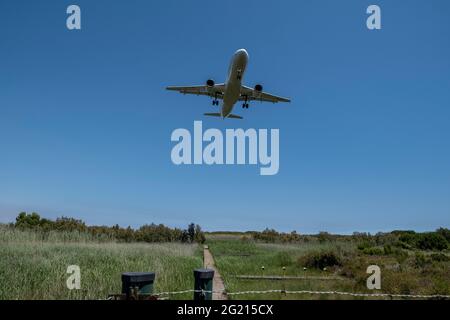 Barcelona, Spanien. Juni 2021. Ein Flugzeug fliegt über dem Agrarpark Baix Llobregat.das Projekt zur Erweiterung einer der Start- und Landebahnen des Flughafens Josep Tarradellas, der im Volksmund als Barcelona's Prat Airport bekannt ist, Droht, in ein geschütztes Gebiet der Feuchtgebiete des Naturparks Delta del Llobregat einzudringen und eine bittere Debatte über das Gleichgewicht zwischen Wirtschaft und Umweltschutz zu eröffnen. (Foto von Paco Freire/SOPA Images/Sipa USA) Quelle: SIPA USA/Alamy Live News Stockfoto