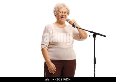 Ältere Dame, die vor einem Mikrofon auf weißem Hintergrund isoliert steht Stockfoto