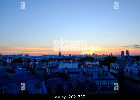 Die Skyline von Paris und die Dächer in der Abenddämmerung am 14. Juli, kurz vor dem großen Feuerwerk am Nationalfeiertag. Eine Mischung aus blauer Stunde und Sonnenuntergang. Die Sonne ist untergegangen Stockfoto