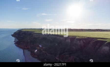 Steile Sandklippe an der Küste bei Sonnenaufgang Stockfoto