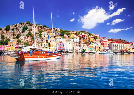 Symi Island, Griechenland. Griechenland Inseln Urlaub von Rhodos in der Ägäis. Farbenfrohe neoklassizistische Häuser in der Bucht von Symi. Hintergrund der Urlaubsreise. Stockfoto