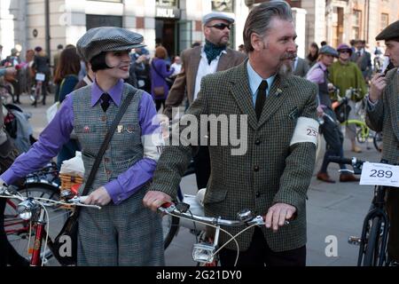 Ein Tweed-gekleidetes Paar posiert mit seinem Fahrrad beim London Tweed Run. Stockfoto