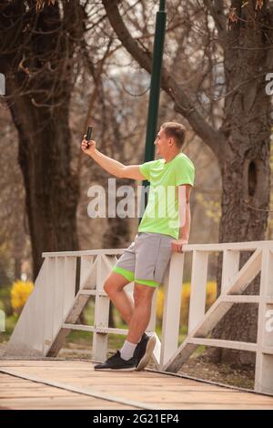 Sportman macht eine Pause, während er ein Selfie auf seinem Handy macht Stockfoto