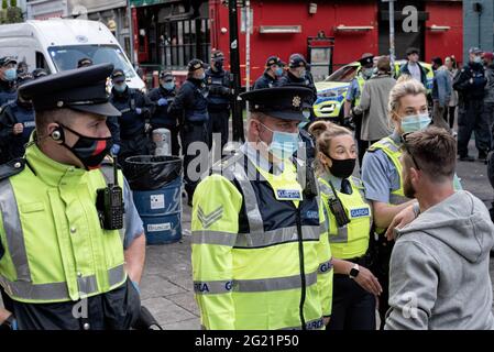 Um die Massen zu zerstreuen, gehen mehrere Polizisten während der Feiertage die South William Street entlang. Seit dem 2021. April hat Dublin die Beschränkungen allmählich gelockert, und da der Feiertag am Montag, dem 7. Juni, das Wetter aufwärmte und öffentliche Toiletten auf den Straßen installiert wurden, entschieden sich mehrere Menschen, das Wochenende im Stadtzentrum mit Freunden und Freunden zu verbringen. Die große Menge führte zu Spannungen wie Flaschen, die auf die Polizei geworfen wurden, Personen, die sich weigerten, umzusiedeln, als die Polizei sie dazu aufforderte, und anderen Vorfällen, die bis heute zu 47 Verhaftungen führten. Stockfoto