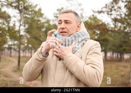 Älterer Mann mit Inhalator in Asthmaanfall im Freien Stockfoto