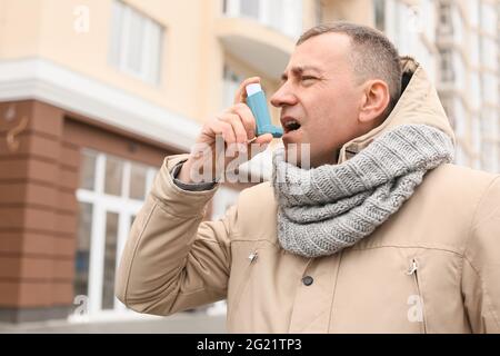 Älterer Mann mit Inhalator in Asthmaanfall im Freien Stockfoto