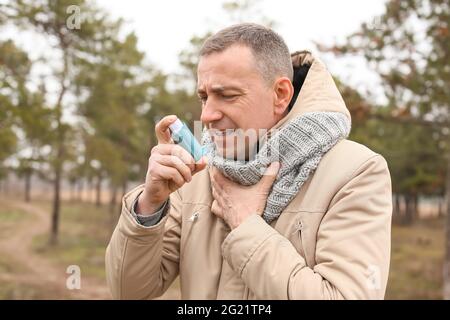 Älterer Mann mit Inhalator in Asthmaanfall im Freien Stockfoto
