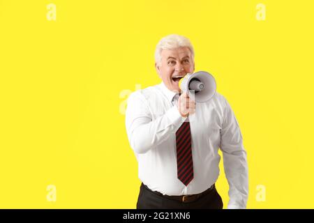 Screaming reifen Geschäftsmann mit Megaphon auf farbigem Hintergrund Stockfoto