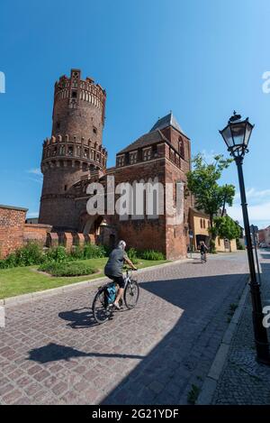 05. Juni 2021, Sachsen-Anhalt, Tangermünde: Ein Radfahrer fährt am Neustädter Tor vorbei. Die dahinter liegende Altstadt zieht jedes Jahr viele Touristen an, vor allem Wanderer und Radfahrer. Die Hansestadt Tangermünde liegt direkt am Elberadweg. Mit seinen Backstein- und Fachwerkgebäuden ist sie eine der ältesten Städte der Altmark. Foto: Stephan Schulz/dpa-Zentralbild/ZB Stockfoto