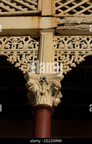 Detail der ausgefallenen gusseisernen Spitzenbesatz auf einem alten Gebäude mit Nahaufnahme von ausgefallenen Pfosten. Stockfoto