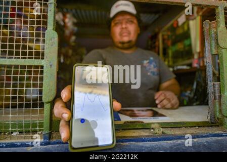 Chiltuipan, El Salvador. Juni 2021. Ein Mann hält ein Mobiltelefon, das eine Anwendung anzeigt, die den Kurs und das Diagramm von Bitcoin zeigt. Der salvadorianische Präsident Nayib Bukele hat angekündigt, dass er dem Kongress ein Gesetz vorschlagen wird, in dem seine Partei die Mehrheit kontrolliert, damit Bitcoin zum legalen Zahlungsmittel wird. El Salvador würde das erste Land der Welt werden, das eine Kryptowährung als gesetzliches Zahlungsmittel akzeptiert. Kredit: SOPA Images Limited/Alamy Live Nachrichten Stockfoto