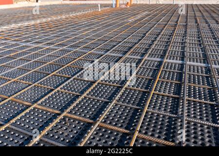 Nahaufnahme der Betonbewehrung. Geometrische Ausrichtung der Resten auf der Baustelle. Verstärkungen Stahlstäbe stapeln. Stockfoto