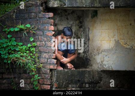 Allein Junge unter der Brücke sitzen Stockfoto