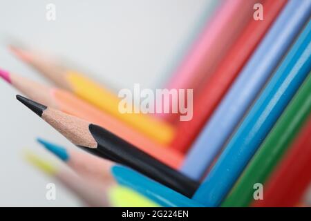 Viele mehrfarbige scharfe Holzstifte liegen im rechten Winkel Nahaufnahme Hintergrund Stockfoto