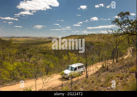 Eine isolierte Feldstraße, die sich durch das malerische Tal zwischen Lapa Junction und Mt Garnet in Queensland, Australien, schlängelt. Stockfoto