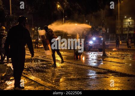 5. Juni 2021, Bogota, Kolumbien: Polizeiwagen sprüht während der Demonstration Wasserwerfer auf Demonstranten.am 4. Juni befahl die kolumbianische Regierung den Demonstranten, das freiwillige medizinische Lager, Plätze am 'Amerikanischen Tor', umbenannt in 'Widerstandstor' in BogotÂ·, zu demontieren. Als Reaktion darauf baten Menschenrechtsorganisationen den Bürgermeister von BogotÂ·, ihnen einen optionalen Platz zur Einrichtung des medizinischen Lagers zu geben. Sie erhielten keine Antwort und wurden stattdessen am Abend von der Anti-Aufstandspolizei angegriffen. Die Demonstranten wurden mit Tränengaskanistern, Betäubungsgranaten und Wasserwerfern beschossen. Die conf Stockfoto