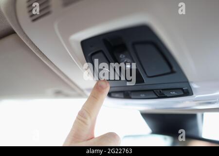 Mann mit dem Finger, der in der Nahaufnahme des Autos den Notausschalter drückt Stockfoto