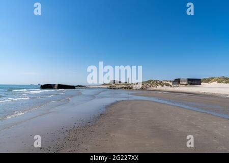 Landschaftsansicht von alten Bunkern an den Stränden von Skagen in Norddänemark mit dem Leuchtturm im Hintergrund Stockfoto