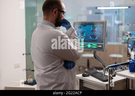 Wissenschaftler besorgt über die Evolution des Virus Analyse DNA-Scan-Bild stehend, in einem ausgestatteten Labor am Computer. Material, das die Entwicklung von Impfstoffen mithilfe von Hightech-Forschungsmethoden untersucht. Stockfoto