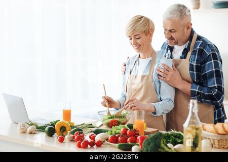 Ältere Blogger, die Videoinhalte aufzeichnen und gesunde Lebensmittel in der Küche zubereiten Stockfoto