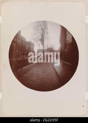 Die Keller in Leeuwarden. Die Keller in Leeuwarden von der Ecke der Minnemerstraat aus gesehen, mit Leuten, die auf dem Kai spazieren. Das Foto ist Teil eines Albumblatts mit Fotos von Leeuwarden Stockfoto